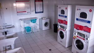 a laundry room with washing machines and a sink at Studio completo e aconchegante in Ribeirão Preto