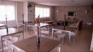 a large room with tables and chairs and a kitchen at Studio completo e aconchegante in Ribeirão Preto