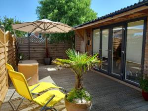 トローブリッジにあるCrown Cabin Wiltshire near Longleat and Bathのパティオ(黄色い椅子、パラソル付)