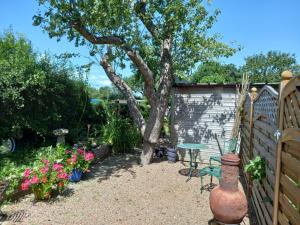 a garden with a tree and a table and a fence at Crown Cabin Wiltshire near Longleat and Bath in Trowbridge