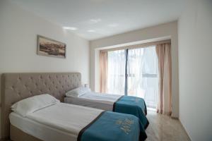 a hotel room with two beds and a window at Antik Apartments in Balchik