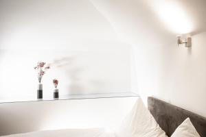Schlafzimmer mit weißen Wänden und einem Bett mit weißen Kissen in der Unterkunft restaurant271 in Burghausen