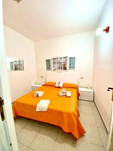 a bedroom with a orange bed with towels on it at Appartamento Fronte Mare in Santa Teresa Gallura