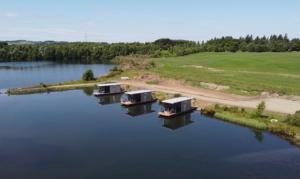 una vista aerea di tre cottage su un lago di Couston Lakes Resorts a Bathgate
