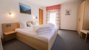 a bedroom with a bed with white blankets and pillows at Ferienhaus Stubai in Neustift im Stubaital