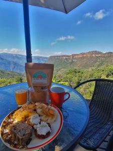 a plate of breakfast food on a table with a view at Domo Geodésico frente al Cañón del Chicamocha in Los Santos