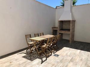 una mesa de madera y sillas en un patio con chimenea en C.R. Tierras del Cabriel, en Minglanilla