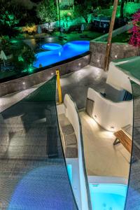 uma vista para uma piscina à noite em Anila Suites em Fira
