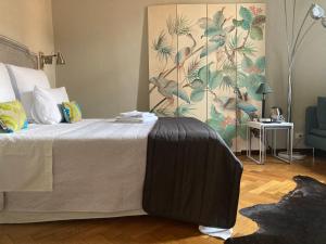 a bedroom with a bed with a painting on the wall at Liberty House in Bologna