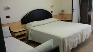una habitación de hotel con 2 camas y una silla en Hotel Trocadero, en Riccione