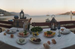 a table with plates of food on it with a view of the water at Symi . VILLA CALME (Sur la Mer). in Symi