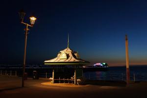 a gazebo with a clock on it near the ocean at night at Brecks Hotel in Blackpool