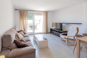 sala de estar con sofá y TV en Soling 19 en La Manga del Mar Menor