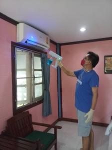 a person playing with a blow dryer in a room at Haad Somboon House in Bang Saphan