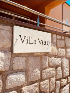 a sign on the side of a stone wall at VillaMar in Pag