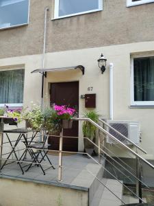 un patio con mesa, sillas y flores en Apartamentai 555, en Vilna