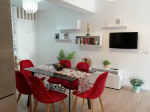 a dining room with a table and red chairs at Pensiunea Timiș in Borşa