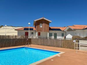a swimming pool in front of a house at Residence Plage Oceane in Biscarrosse-Plage