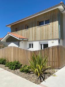 a wooden fence in front of a house at Residence Plage Oceane in Biscarrosse-Plage