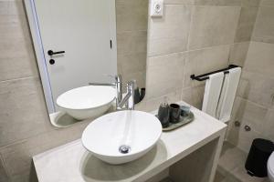 a bathroom with a white sink and a mirror at Casas do Mercado - Casa Sirius in Angra do Heroísmo