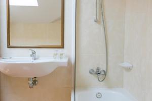 a bathroom with a sink and a shower with a mirror at Hotel O Castro in Reboredo