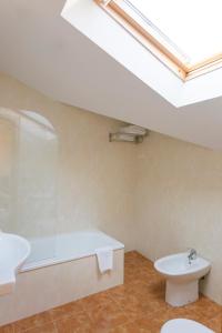 La salle de bains est pourvue d'un lavabo, d'une baignoire et de toilettes. dans l'établissement Hotel O Castro, à Reboredo