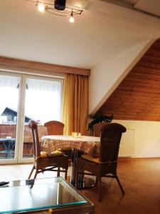 ein Wohnzimmer mit Tisch und Stühlen und einem Fenster in der Unterkunft Ferienwohnung Gruß aus Partenkirchen in Garmisch-Partenkirchen