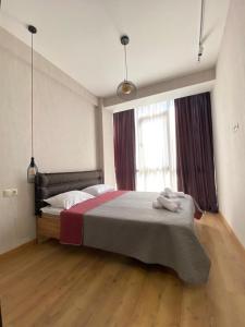 a bedroom with a large bed and a window at Villa Residence Apartment in Tbilisi City