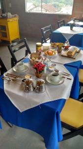 a table with a blue table cloth with food on it at Pousada Morena SFX in São Francisco Xavier