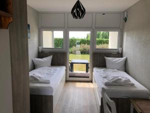 twee bedden in een kamer met een raam bij Bauernhof Köhlbrandt in Todendorf auf Fehmarn