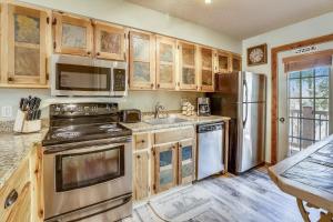 una cocina con electrodomésticos de acero inoxidable y armarios de madera en Multi-level Cedars 2 Townhome en Breckenridge