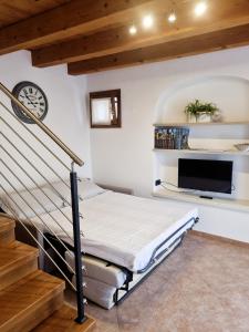 a bedroom with a bed and a flat screen tv at Giulietta e Romeo in Pove del Grappa