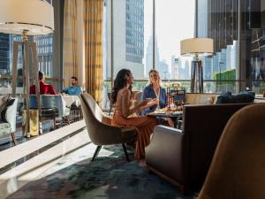 two women sitting at a table on the top of a building at Four Seasons Hotel Dubai International Financial Centre in Dubai