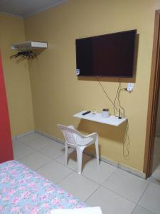 a room with a table and a tv on a wall at Hotel 678 in Boa Vista