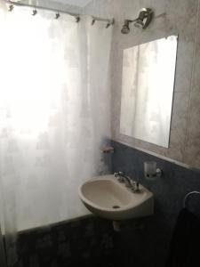 een badkamer met een wastafel, een spiegel en een raam bij Departamento Congreso de Tucuman 561 in San Miguel de Tucumán