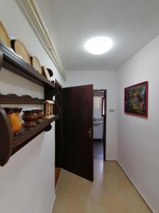 een kamer met een deur en een plank met potten en pannen bij Hiša Žičanka in Loče pri Poljčanah