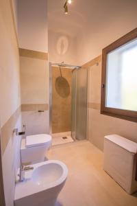 a bathroom with a toilet and a sink and a shower at Villa Ginepro (Country House) in Dorgali
