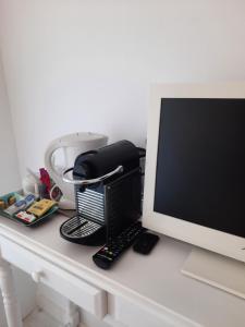 einen Schreibtisch mit einem Computermonitor und einer Tastatur in der Unterkunft AGATHE chambres d'hôtes in Guérande