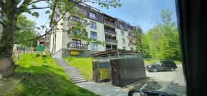 a building with a car parked in front of it at Apartamenty EverySky - Źródlana 2 in Świeradów-Zdrój