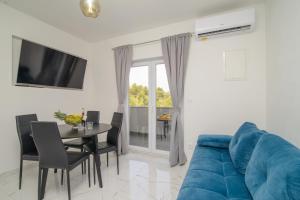 a living room with a blue couch and a table at Apartments Pelja in Trogir