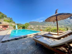 - une piscine avec un parasol et des chaises longues à côté dans l'établissement Fabulous Rustic Villa Set On Mountain With Unique Views, à Valldemossa