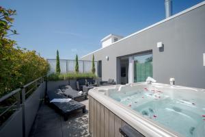 a hot tub on the balcony of a house at Central Park Hôtel & Spa in La Rochelle