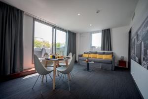 a living room with a table and chairs and a couch at Central Park Hôtel & Spa in La Rochelle