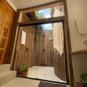 a room with a sliding glass door with plants at Villa Papagaio in Jijoca de Jericoacoara