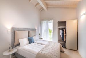 a bedroom with a large white bed and a window at Pareus Beach Resort in Caorle +37 photos