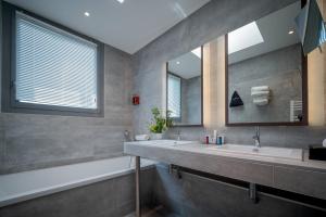 a bathroom with two sinks and a mirror at Central Park Hôtel & Spa in La Rochelle +31 photos