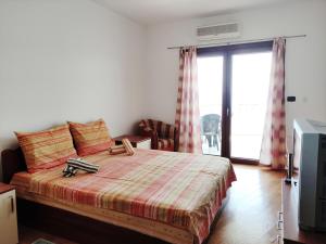 une chambre avec un grand lit et une télévision dans l'établissement Apartments Altea, à Rafailovici