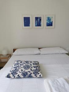 a white bed with a blue and white pillow on it at Domus Taura in Terracina