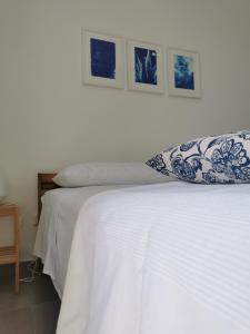 uma cama branca com uma almofada em cima em Domus Taura em Terracina