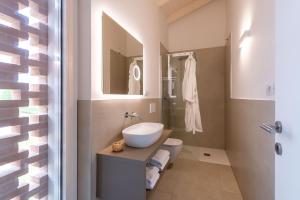a bathroom with a sink and a toilet at Pareus Beach Resort in Caorle